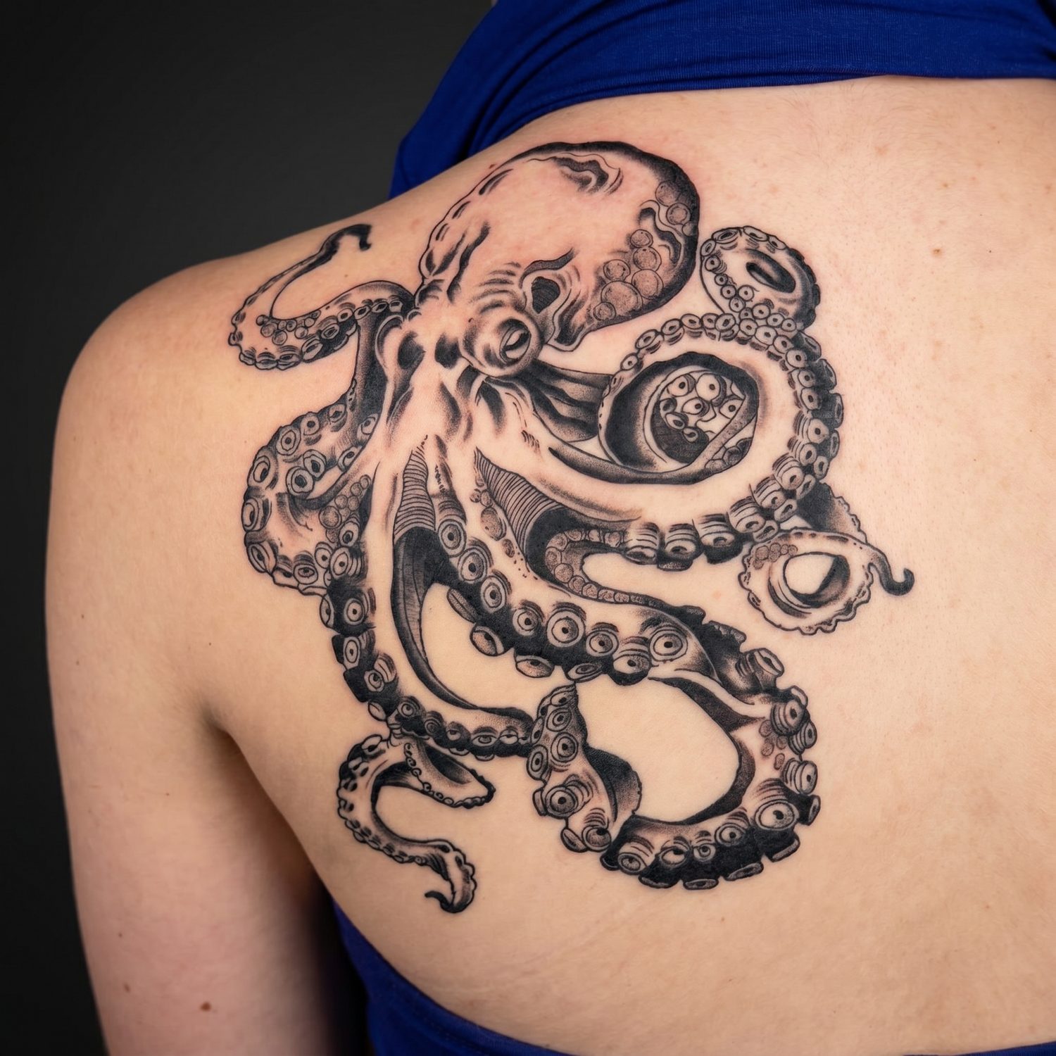 Black and grey octopus back tattoo